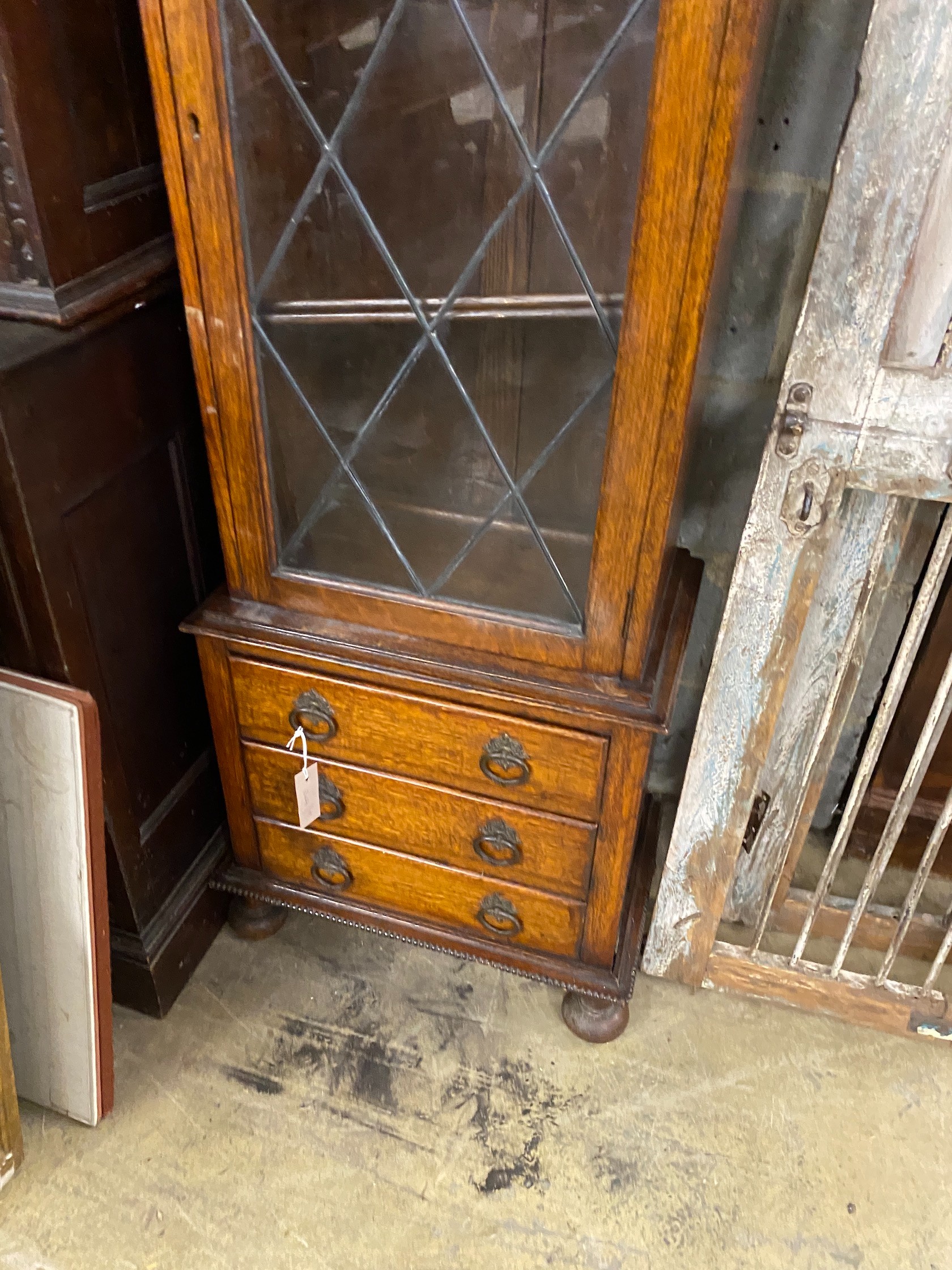 A 1920's narrow oak leaded glazed bookcase, width 52cm, depth 32cm, height 151cm